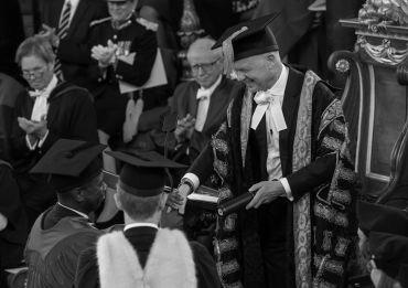 Image depicts Clive Myrie receiving his honorary degree from the Chancellor
