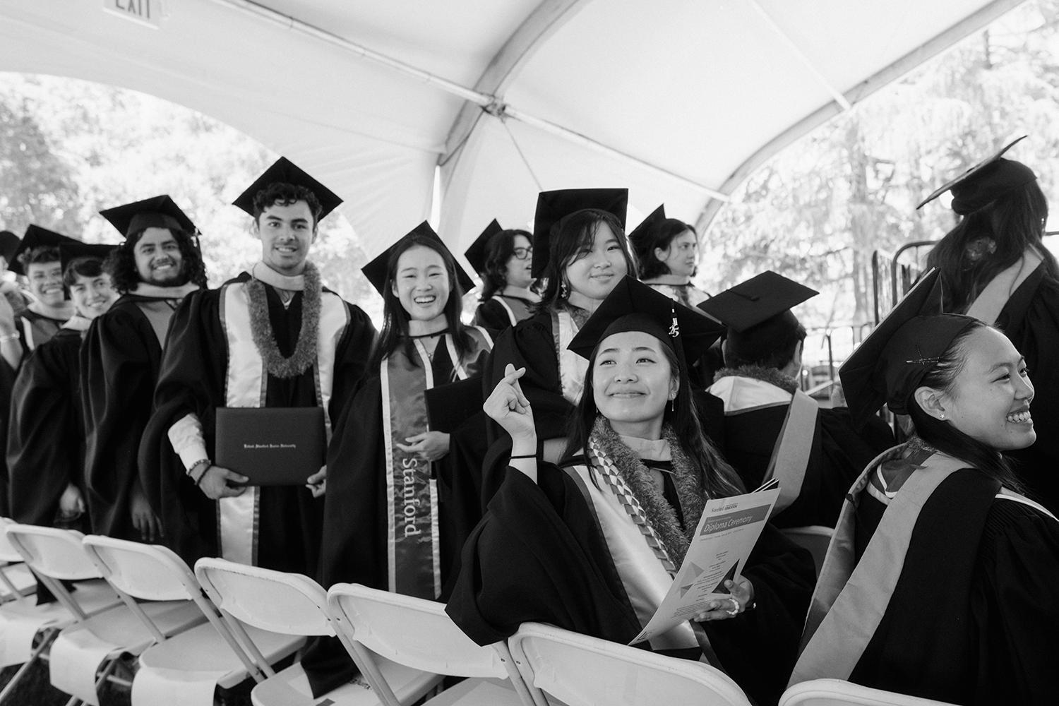 Image of graduating students holding their diplomas as they return to their seats.