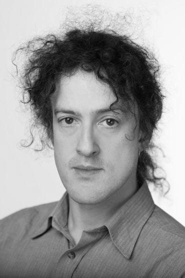 Portrait of Professor Phiip Torr, a white man with curly black hair.