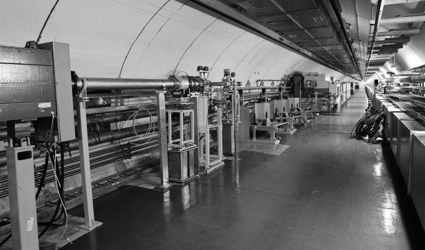 A long chamber with scientific equipment arranged along both sides, with a lot of tubing and wires.