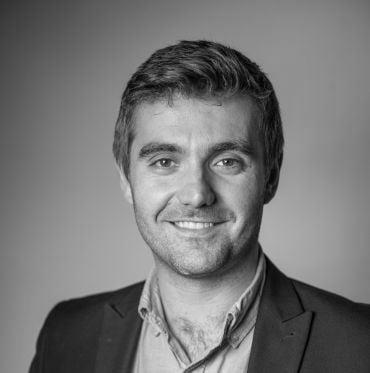 Portrait photo of Professor Robert House, a white man with short brown hair wearing a dark blue suit jacket and light blue shirt.