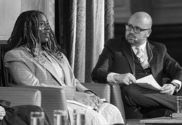 Image shows Dominique Palmer answering a question with Dr Julius Grower watching on