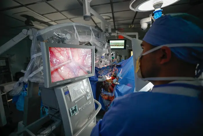 Taylor Furst, M.D., observes a brain mapping procedure in progress at the University of Rochester’s Strong Memorial Hospital. Credit: Matt Wittmeyer