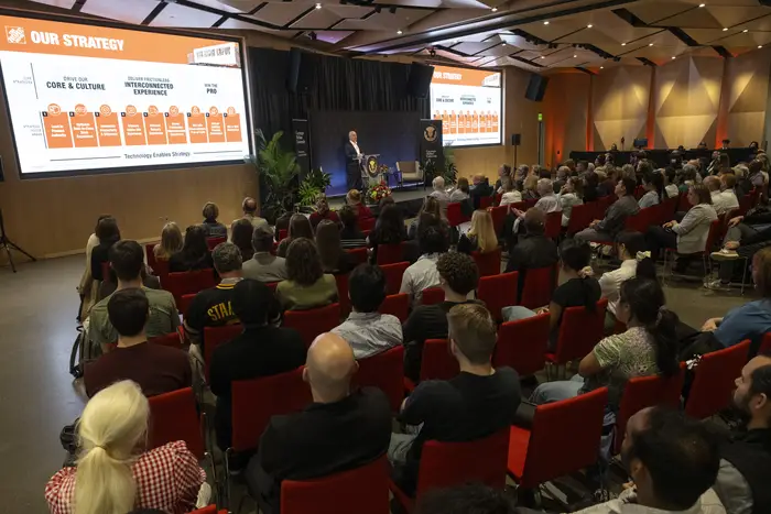 A room of people listens to Ted Decker speak.