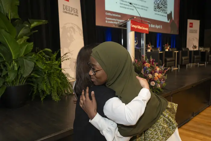 Anna Sène gives someone a hug.