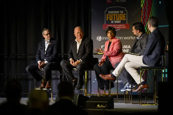 A panel of people speaks from a stage.