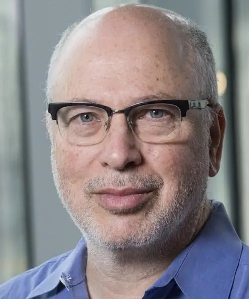 A man wearing glasses and a blue polo shirt